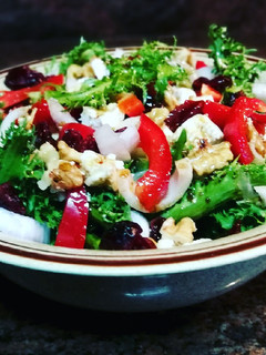 Una foto de Escarola con queso griego, cranberry y nueces