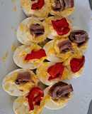 Huevos rellenos de atún decorados con anchoa y pimiento rojo
