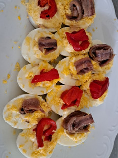 Una foto de Huevos rellenos de atún decorados con anchoa y pimiento rojo