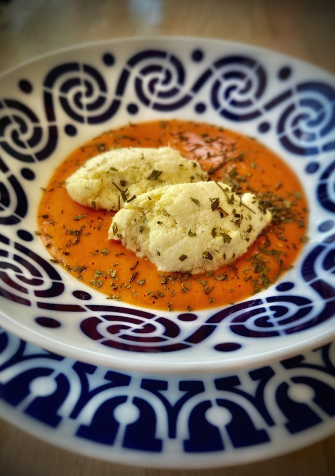 Una foto de Quenelles de brandada sobre crema de salmorejo (en Thermomix)