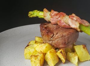 Una foto de Lomo de Res con Papas y Espárragos envueltos en Tocineta