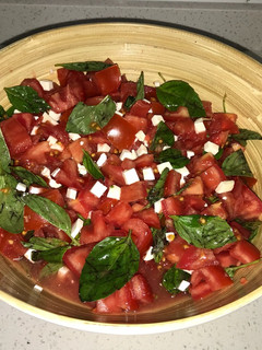 Una foto de Ensalada de tomates con queso de cabra y albahaca
