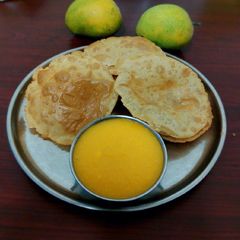 A picture of Aam ras and puri (ras puri).