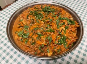Une photo de Poulet aux cacahuètes, carottes, tomates et épices