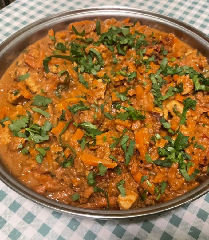 Une photo de Poulet aux cacahuètes, carottes, tomates et épices