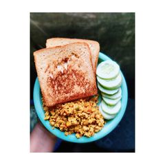 A picture of Scrambled eggs with brown bread and cucumber.