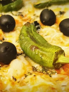 Una foto de Pizza de Bacalao con Pimientos de Padrón y Aceitunas