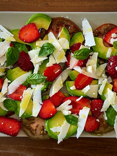 Una foto de Ensalada de tomate, fresas, aguacate, queso y albahaca fresca