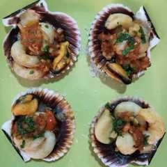 Una foto de Vieira rellena con delicias del mar y aceite perfumado