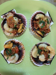 Una foto de Vieira rellena con delicias del mar y aceite perfumado