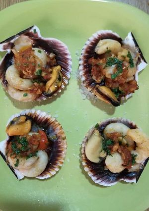 Una foto de Vieira rellena con delicias del mar y aceite perfumado