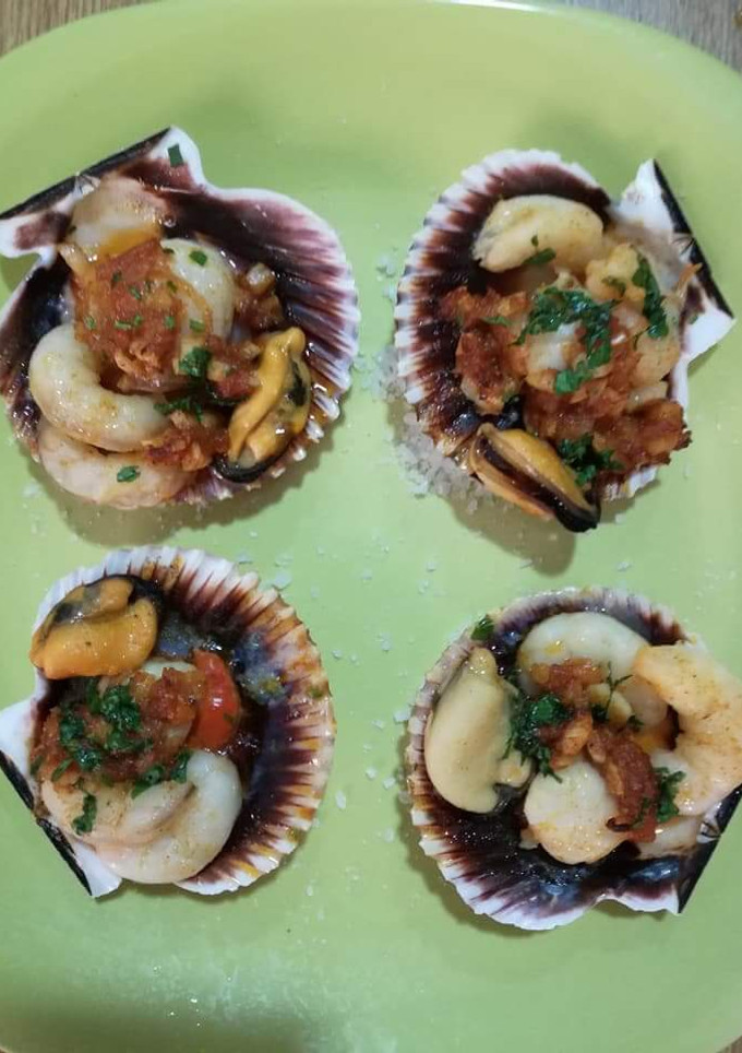 Una foto de Vieira rellena con delicias del mar y aceite perfumado