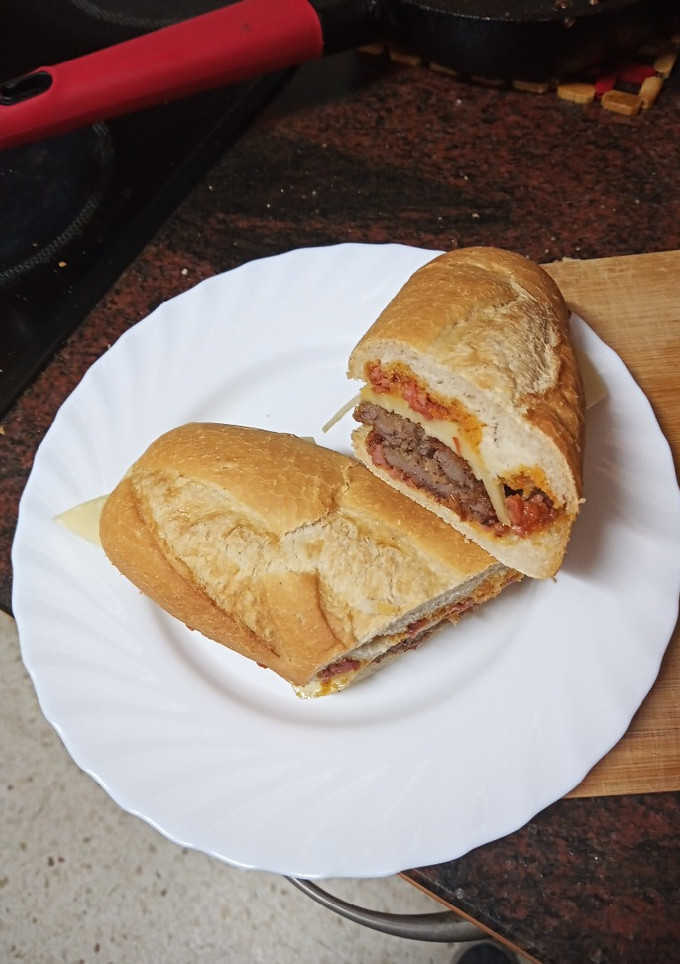 Una foto de Bocadillo de bistec empanado, queso y salsa boloñesa