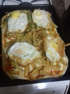 Una foto de Pizza chancha (huevo frito, cebolla frita y papas fritas)