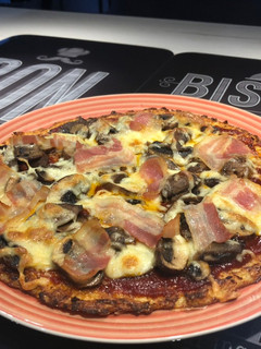 Una foto de Pizza de masa de coliflor con bacon y champiñones