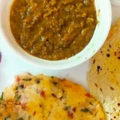 A picture of Sarso Ka saag and chawal ki roti and papad.