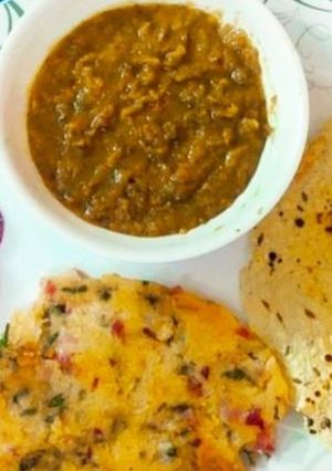 A picture of Sarso Ka saag and chawal ki roti and papad.