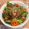 Timbal de Quinoa 3 semillas con palta y salmón junto a lechuga, tomate cherry y semillas de zapallo