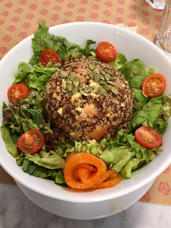 Una foto de Timbal de Quinoa 3 semillas con palta y salmón junto a lechuga, tomate cherry y semillas de zapallo