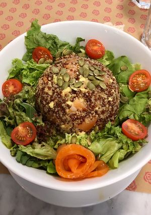 Una foto de Timbal de Quinoa 3 semillas con palta y salmón junto a lechuga, tomate cherry y semillas de zapallo