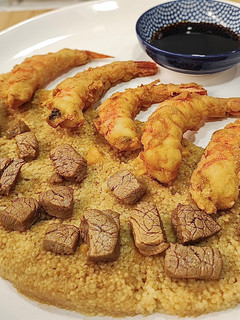Una foto de Gamba roja con harina de garbanzo y cous cous de mango con dados de solomillo de ternera lechal