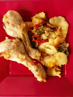 Una foto de Muslitos de pollo al horno con patatas y verduras