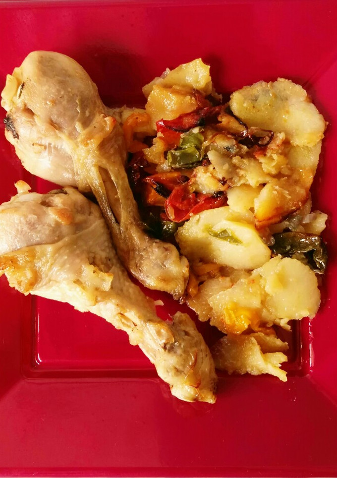 Una foto de Muslitos de pollo al horno con patatas y verduras