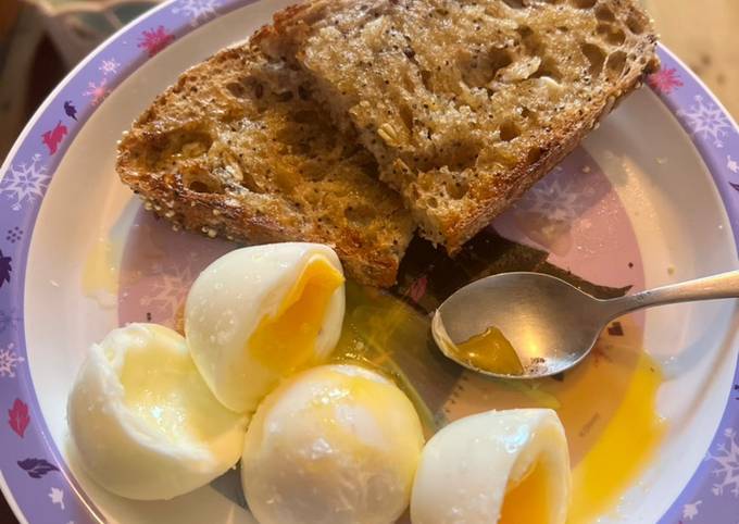 Soft boiled eggs, with a thick slice of buttered, malt seeded bread