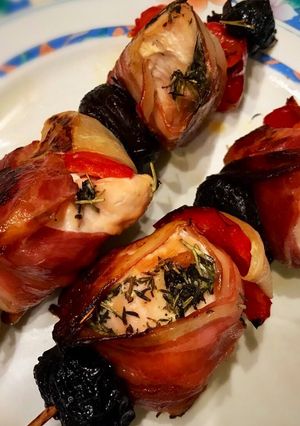 Una foto de Brochette de pollo envuelto en panceta con cebolla, morrón y ciruela seca