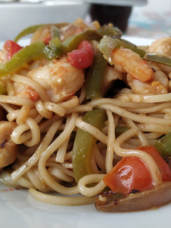 Una foto de Wok de pollo y langostinos