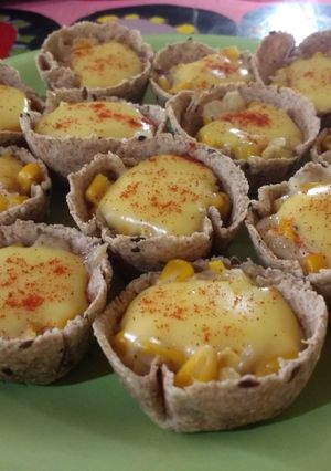 Una foto de Canastitas integrales de cebolla caramelizada, choclo y queso