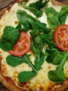 Una foto de Pizza de harina de avena, con rúcula, albahaca y tomate🇺🇾
