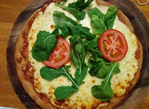 Una foto de Pizza de harina de avena, con rúcula, albahaca y tomate🇺🇾