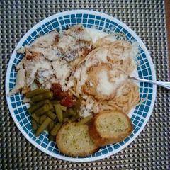 A picture of Chicken Parmesan With Spaghetti and Garlic Bread.