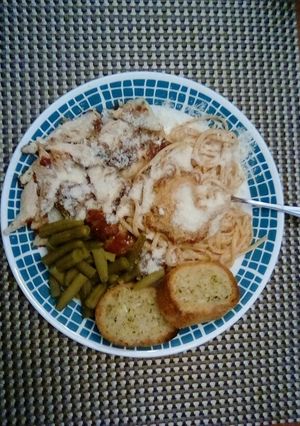 A picture of Chicken Parmesan With Spaghetti and Garlic Bread.