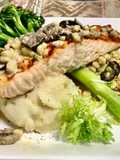 Grilled salmon Topped with a mushroom, Black olives, White corn cream sauce Garlic Mashed potatoes