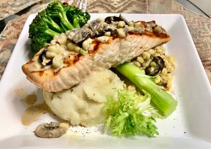 Grilled salmon Topped with a mushroom, Black olives, White corn cream sauce Garlic Mashed potatoes