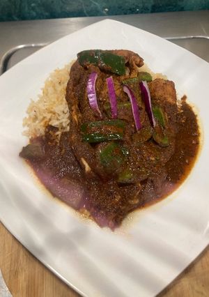 Una foto de Chuleta de res con salsa de chile pasilla y pimiento verde