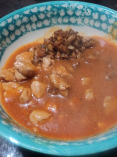 Una foto de Carne de cerdo en salsa de jitomates de milpa, chile de agua moros o pintos y epazote
