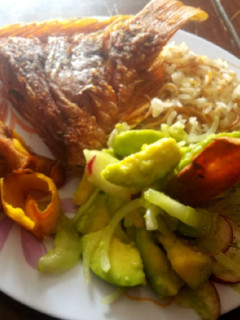 Una foto de Mojarra frita, ensalada, arroz y chips de plátano