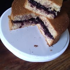 A picture of Sponge cake filled with chunky blue berry jam.