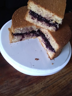 A picture of Sponge cake filled with chunky blue berry jam.