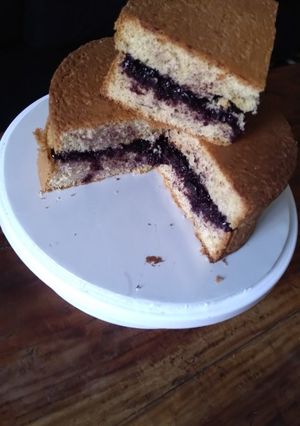 A picture of Sponge cake filled with chunky blue berry jam.