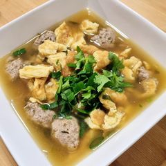 A picture of Thai-style omelette soup with pork balls.
