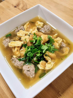 A picture of Thai-style omelette soup with pork balls.