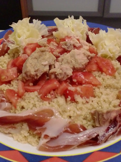 Una foto de Ensalada con cous cous, atún, tomate, jamón y flores de queso