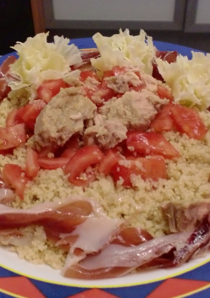 Una foto de Ensalada con cous cous, atún, tomate, jamón y flores de queso