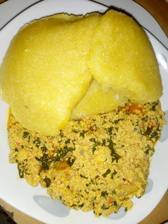 A picture of Egusi soup with yellow eba.