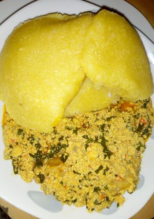 A picture of Egusi soup with yellow eba.
