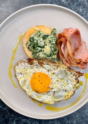 A picture of Creamed spinach on toasted English muffins.